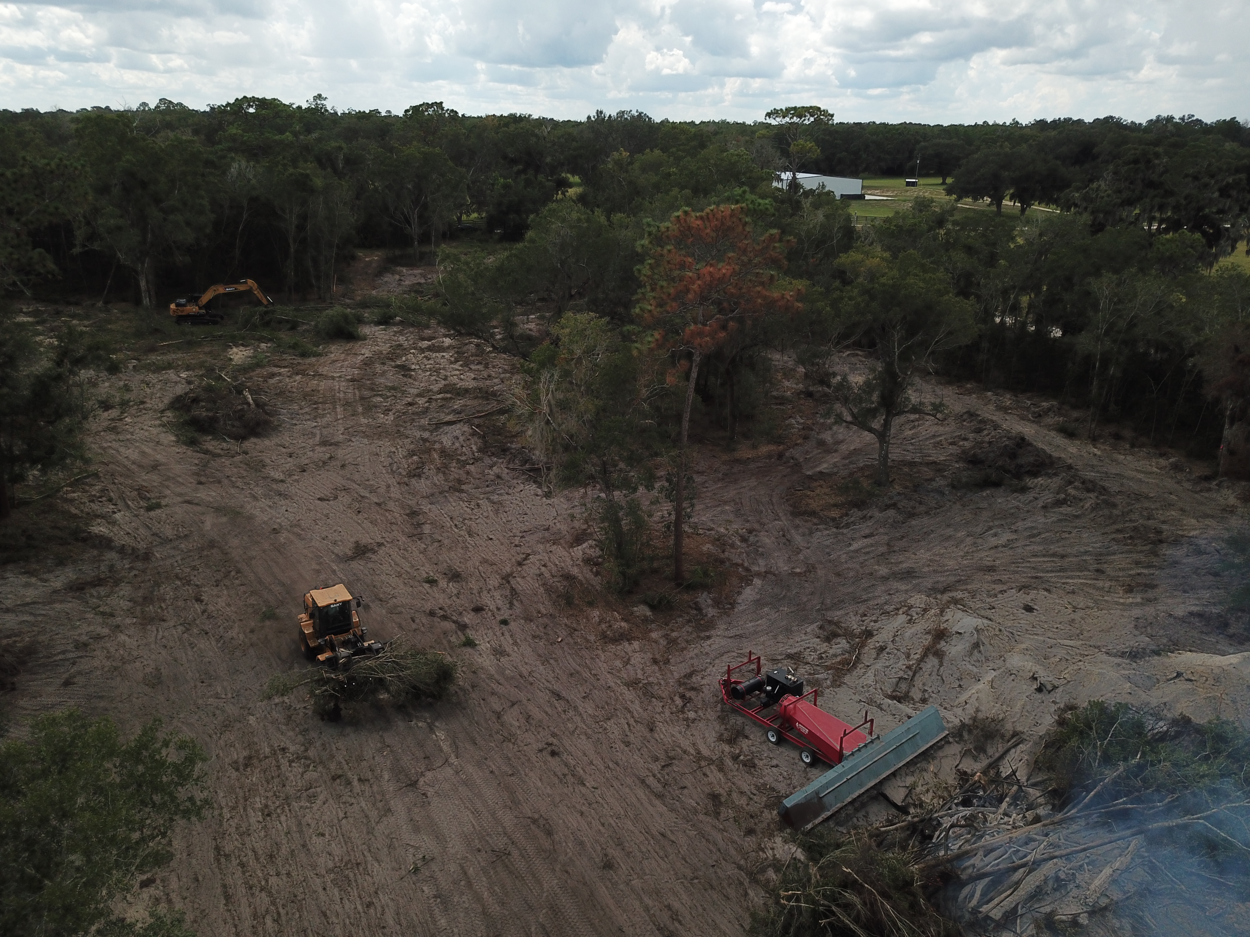 Compact equipment grading a cleared residential lot.